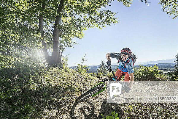 Mountain biker riding in forest  Bavaria  Germany