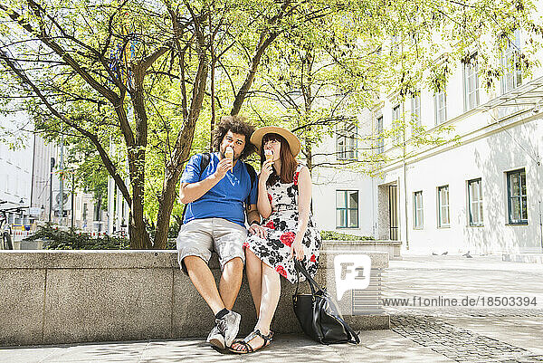 Couple eating ice cream outdoors in city