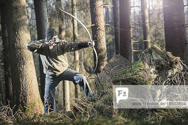 Man shooting with bow and arrow in the forest  Bavaria  Germany