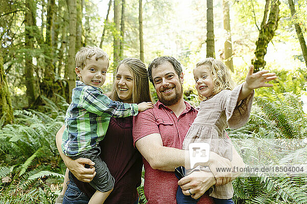 Straight on portrait of a family of four in the forest