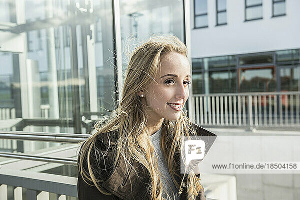 Portrait of a teenage girl smiling in a city street  Munich  Bavaria  Germany