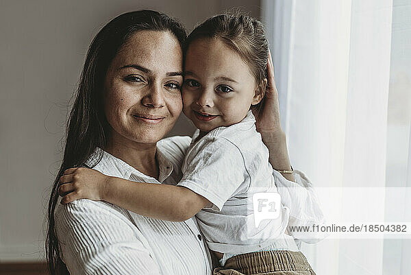 Close up portrait of young mother and toddler son smiling at camera