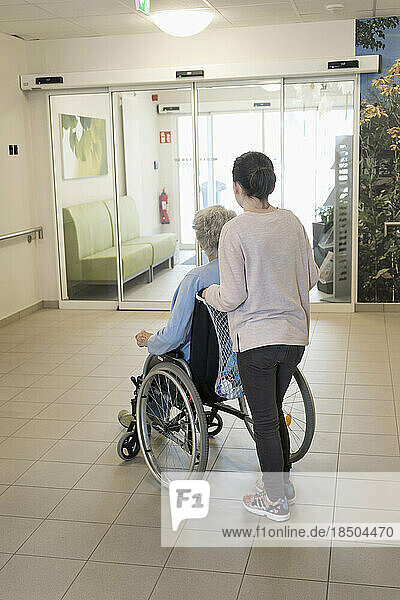 Senior woman in wheelchair with girl in rest home