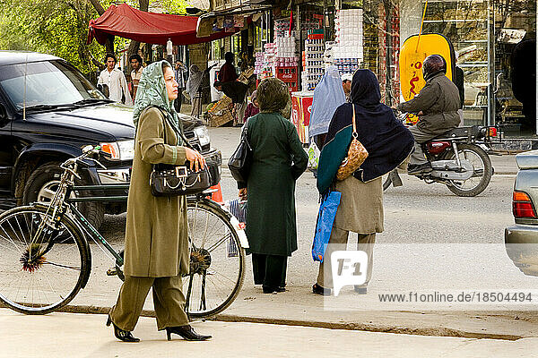 Women on a Kabul street wear headscarves but no burqa.