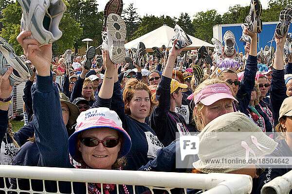 Walkers raise their shoes to honor breast cancer survivors at the end of the 60 mile Komen 3-Day walk for breast cancer in Detro