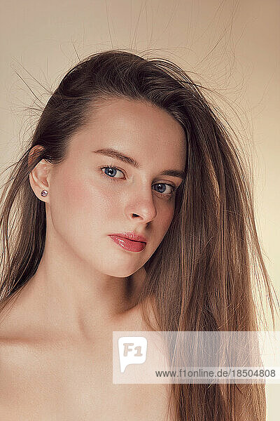 Beauty face of young woman with natural makeup on beige
