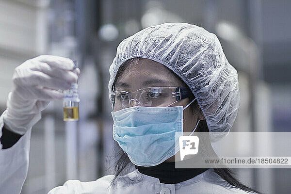 Young female scientist examining test tube in a laboratory  Freiburg im Breisgau  Baden-Württemberg  Germany