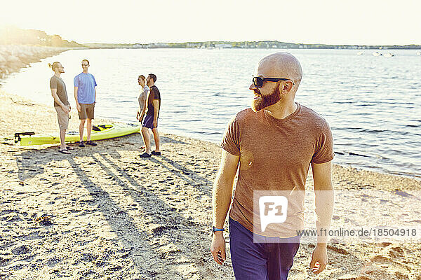 Group of friends hangs out on the beach at sunset in Casco Bay  Main
