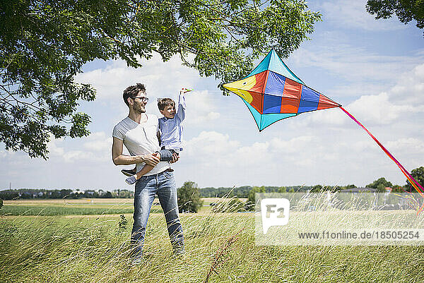 Father and his son flying kite in the countryside  Bavaria  Germany