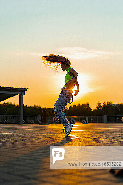 Woman dances at sunset  in motion  flying hair.