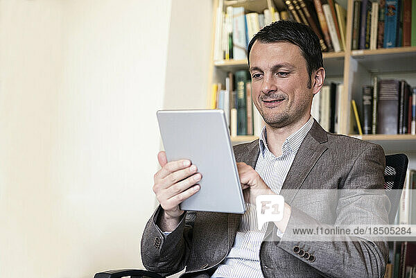 Mature businessman using digital tablet in an office  Bavaria  Germany