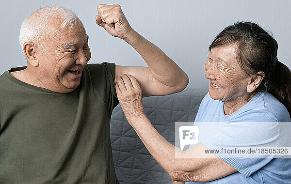 Senior woman checking out her her husband’s biceps