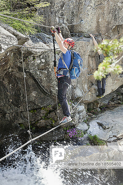 Woman climbing via ferrata towards Stuibenfall Waterfall  Otztal  Tyrol  Austria