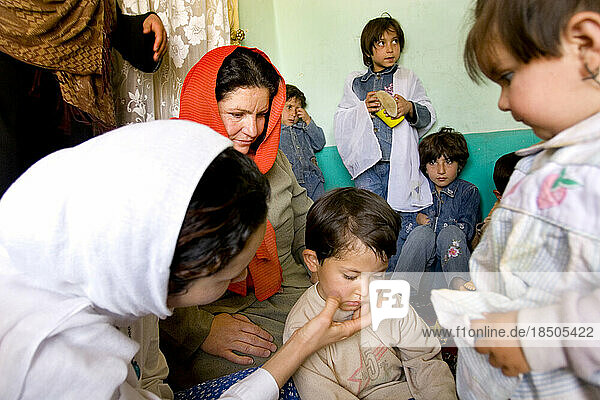 Teachers comfort a crying child at a daycare center in Kabul  Afghanistan.
