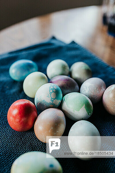 Close up of dyed Easter eggs sitting on blue towel on table