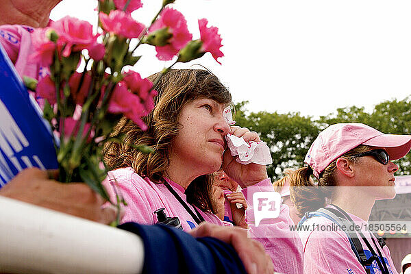 A breast cancer survivor wipes away tears at the closing of the Komen 3-Day walk for breast cancer in Detroit.