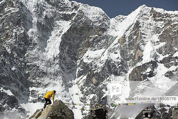 A man scrambles under the mountains of the Himalayas.