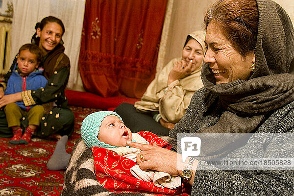 Woman tickles her grandson at her home in Kabul.