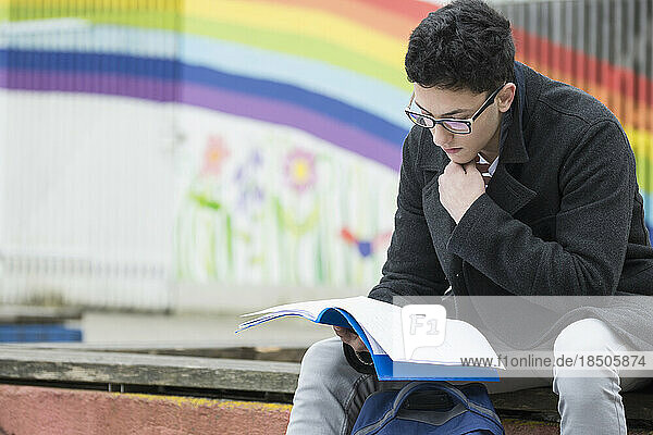 University student reading book in campus School  Bavaria  Germany