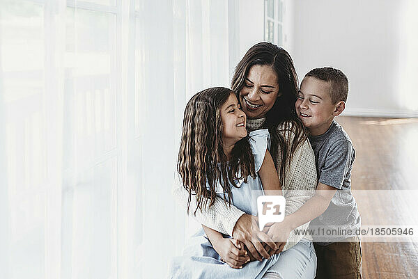 Mother  daughter  and son laughing at each other in studio