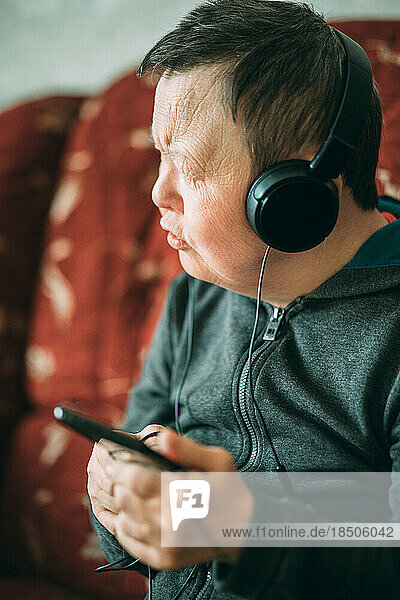 elderly woman with down syndrome with smartphone and headphones