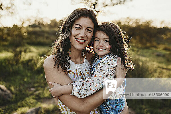 Portrait of young mother and daughter in sunny field