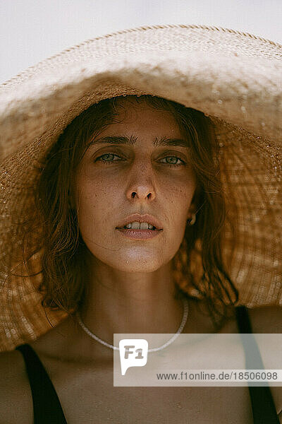 Portrait of a woman in a big straw hat.