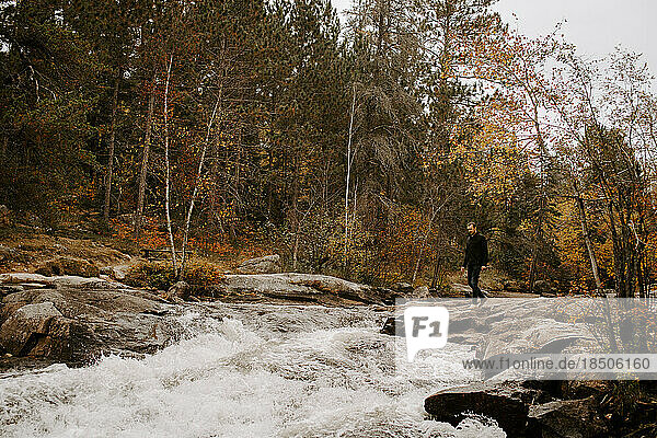 Young man exploring nature by a river in the Canadian Shield
