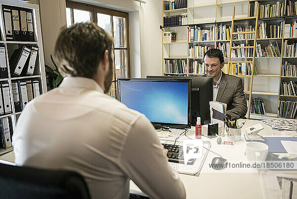 Two businessmen working on computer in an office  Bavaria  Germany