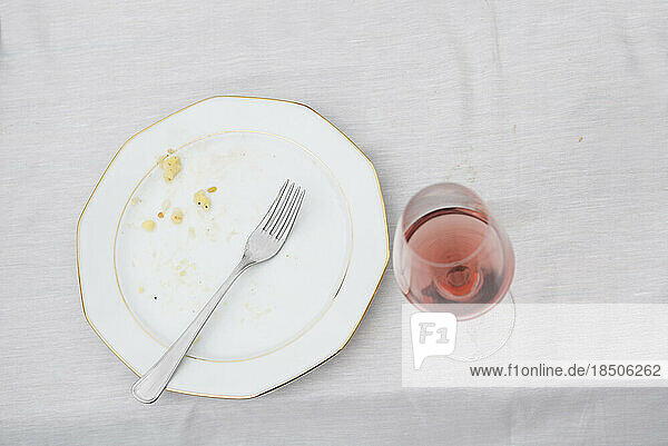 High angle view of plate with remains and half full glass of red wine on picnic table  Bavaria  Germany