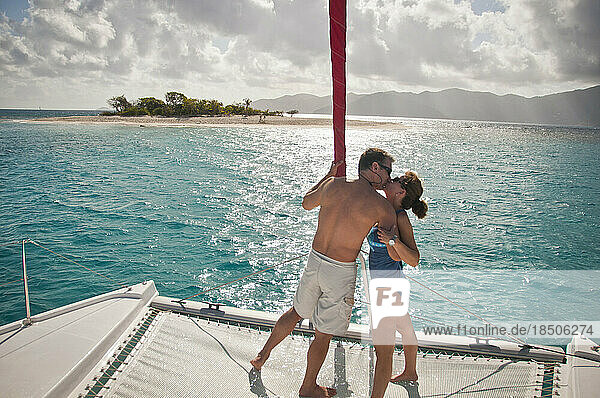 Couple kissing on a sailboat.