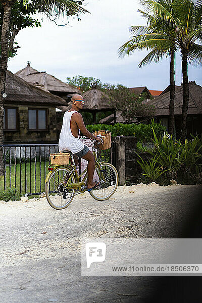 A man rides a bicycle to the beach  Bali.