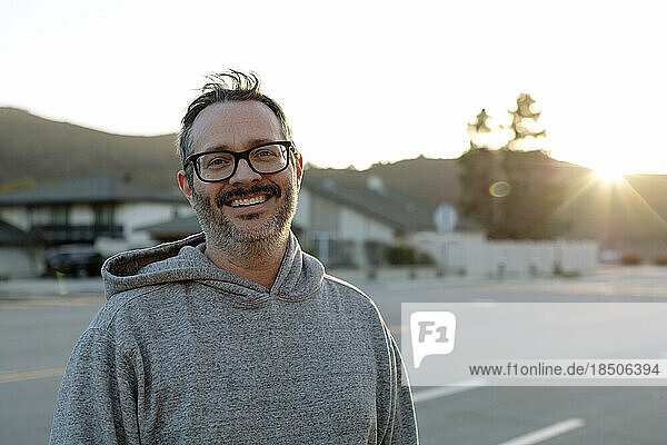 Middle Aged Man With Glasses Smiles While Outside At Sunset