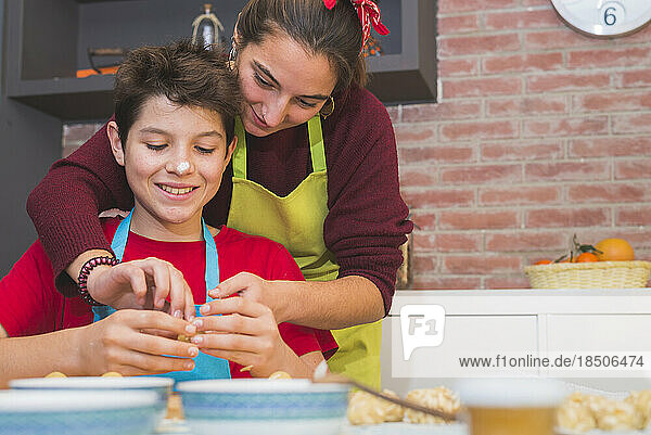 Brothers working with dough and decorating catalonian pastry at