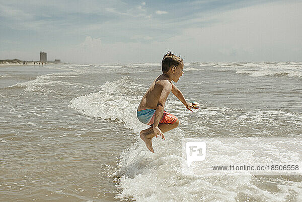 Boy Jumping in Ocean Waves at Beach in Corpus Christi Texas