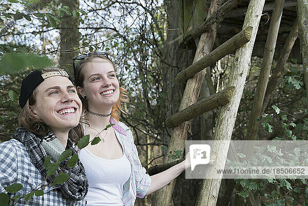 Close-up of young couple standing with ladder of lookout tower and smiling  Bavaria  Germany