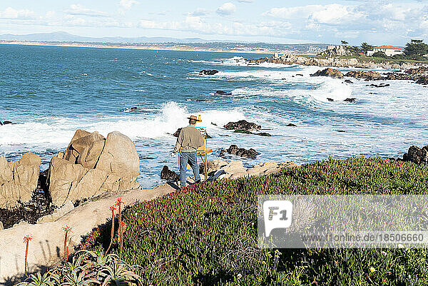 Artist painting landscape in the open air on the coastline of Monterey