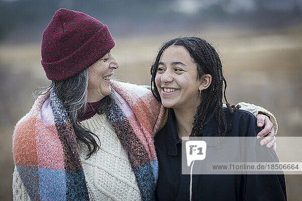 white mother and biracial teen daughter smiling at each other