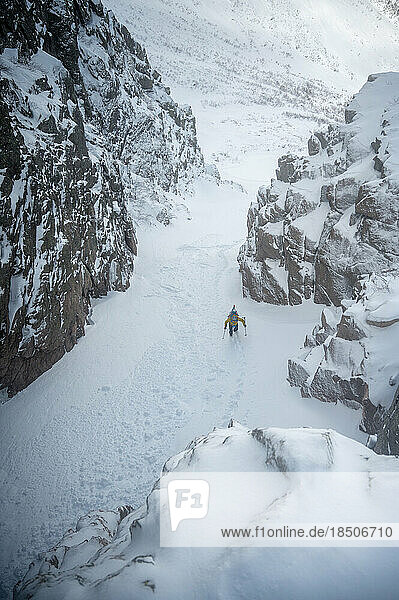 Skiers ascending snowy gully while backcountry skiing