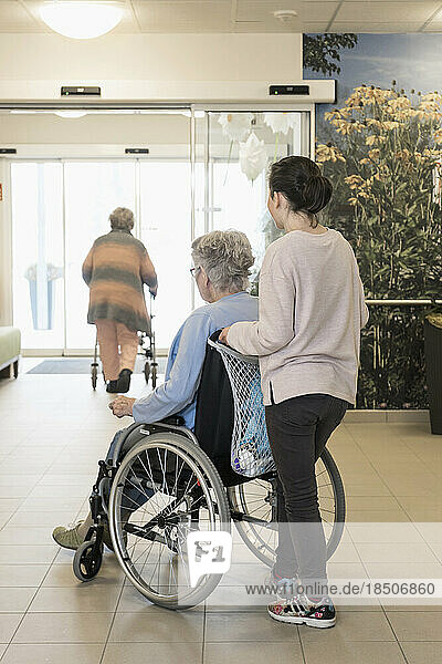 Senior woman in wheelchair with girl in rest home