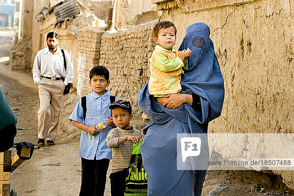 Woman in a burqa with children in Kabul.