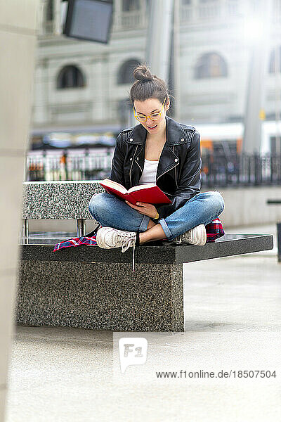 Young woman reading book  waiting at train station