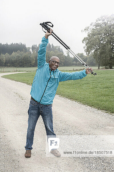 Senior man stretching before Nordic walk with hiking poles  Bavaria  Germany