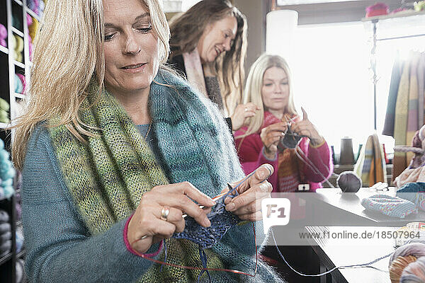 Mature woman knitting muffler in coffee shop  Bavaria  Germany