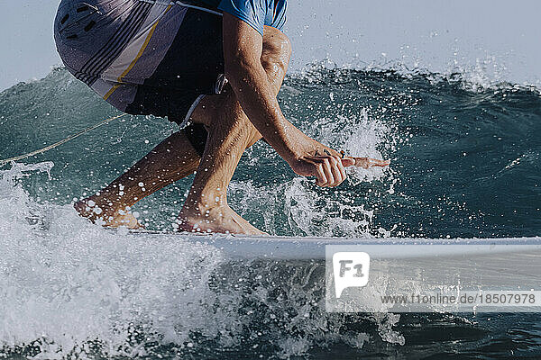 Close up of surfer legs on a surfboard