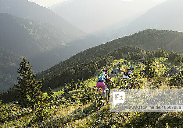 Mountain bikers riding on uphill in alpine landscape  Zillertal  Tyrol  Austria