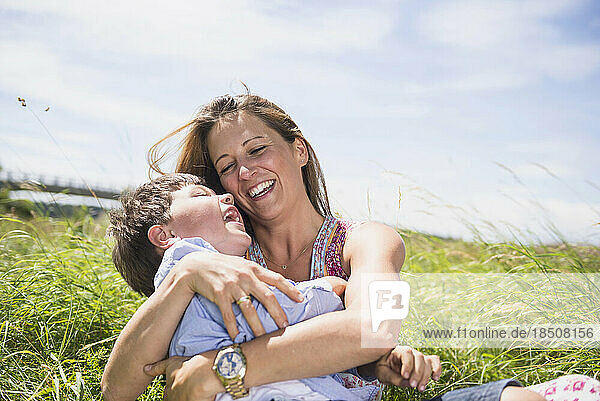 Woman with her son playing on grass and enjoying picnic  Bavaria  Germany