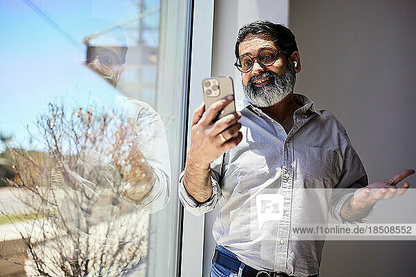 Mature businessman gesturing while talking on video call at cafe