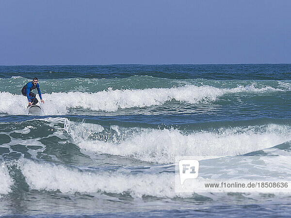 Young man surfing on Sopela Beach  Biscay  Basque Country  Spain