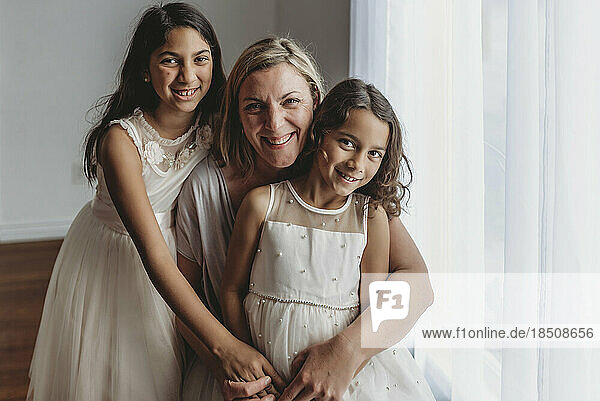 Portrait of mother and daughters smiling at camera in studio